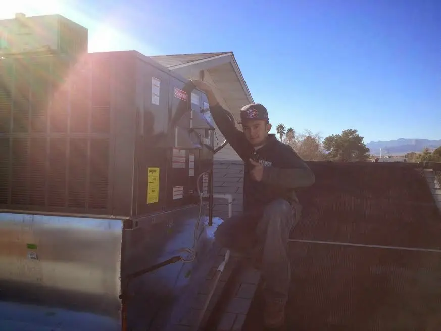 HVAC technician performing Air Duct Repair on a rooftop unit in Tukwila